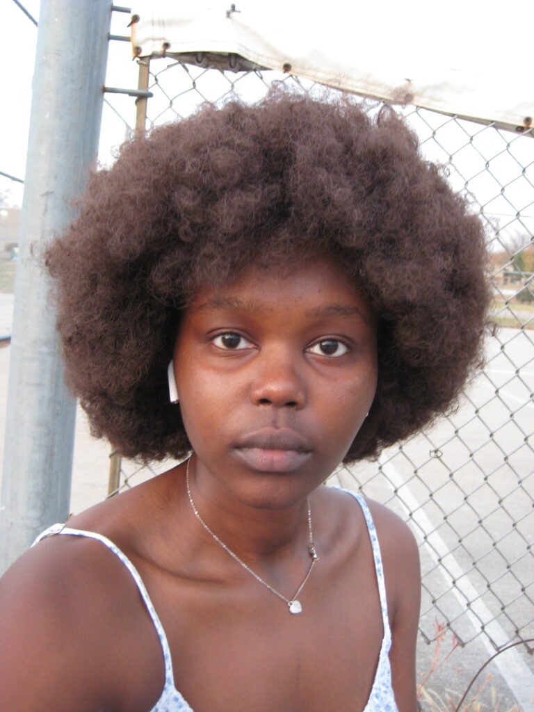 Yar Sudani in an afro wig and no makeup.