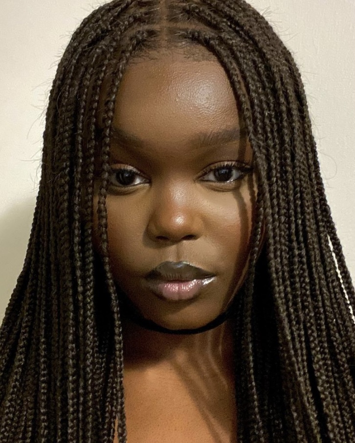 Yar Sudani in a braided wig and natural makeup.