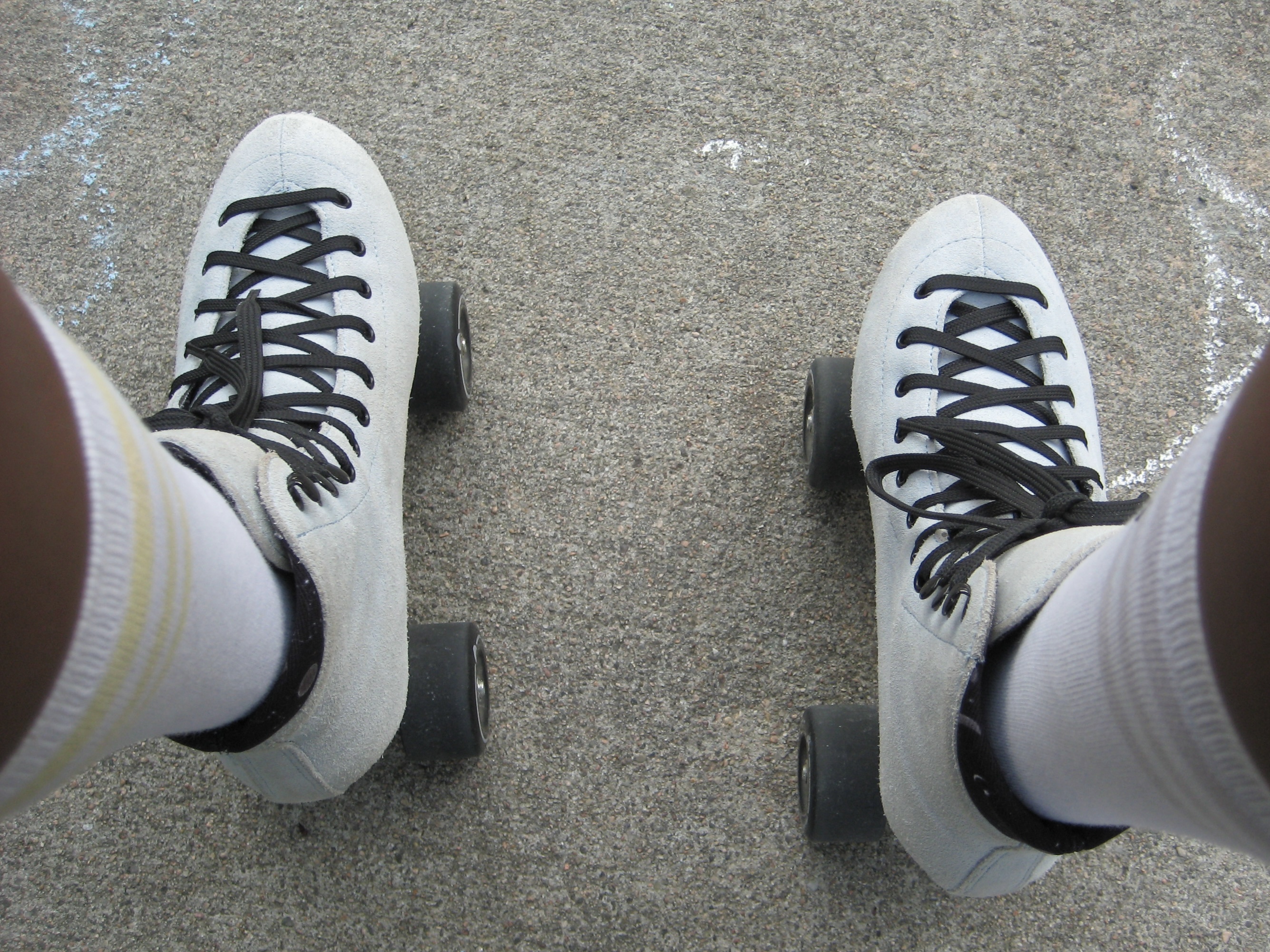 roller-skates on sidewalk that has chalk