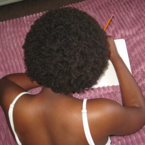 girl with afro writing in diary