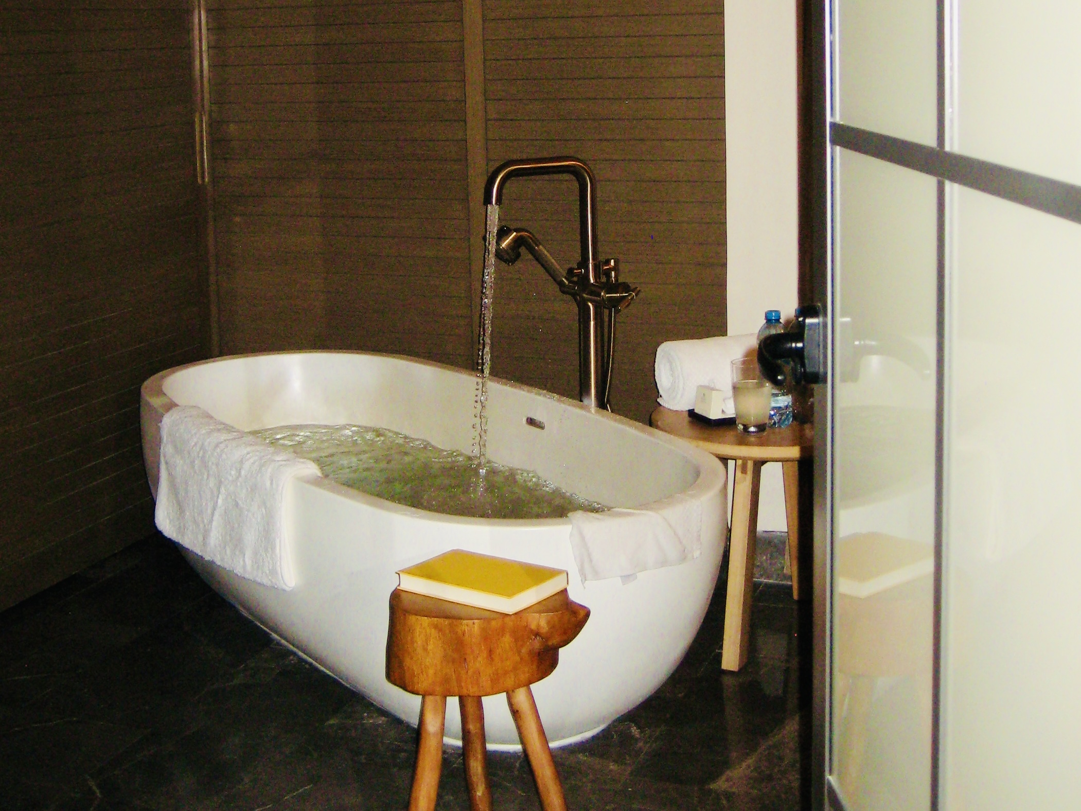 Bath running with book on side table next to it