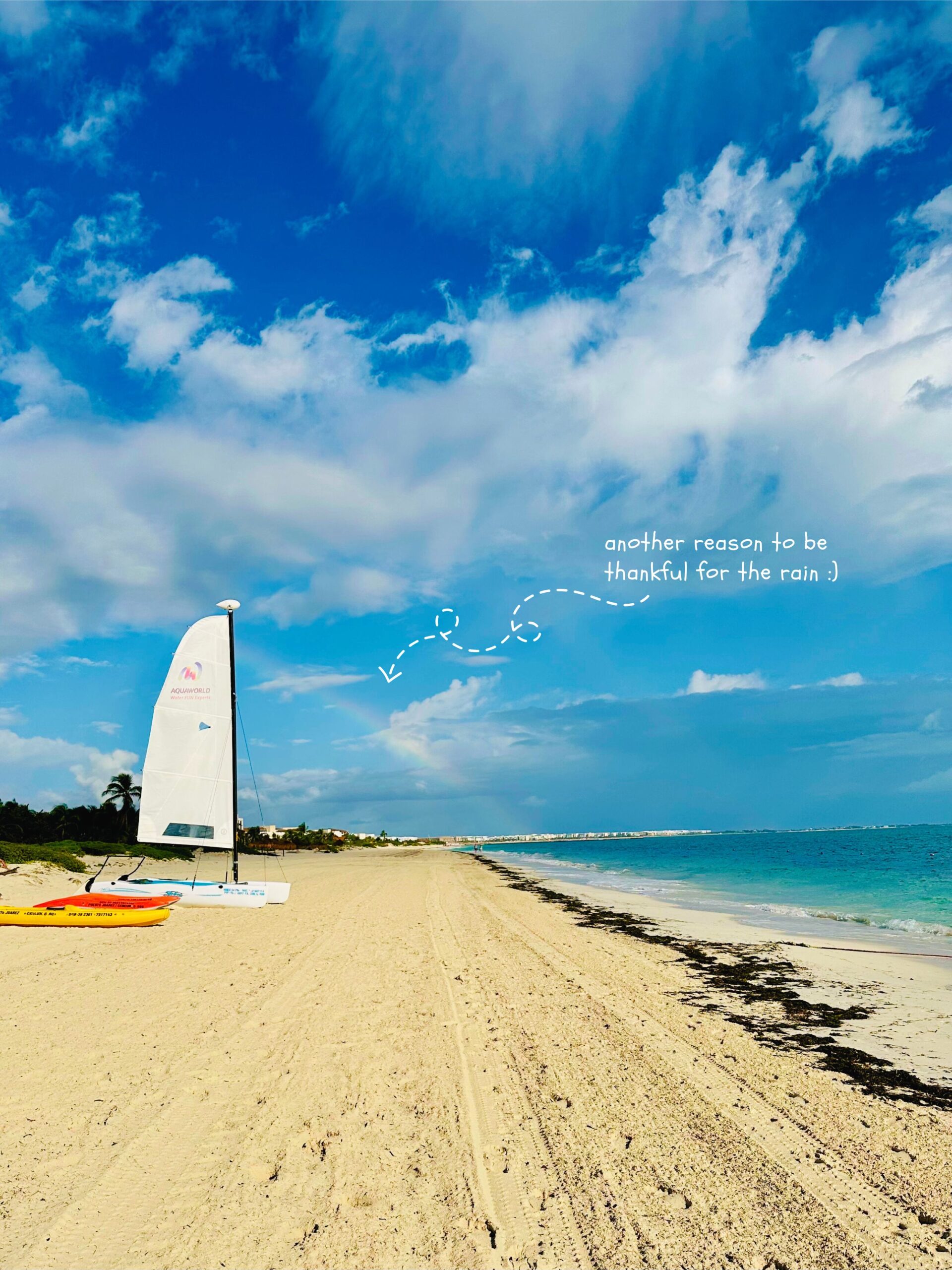 Beach with rainbow visible, text on picture reads: "another reason to be thankful for the rain"