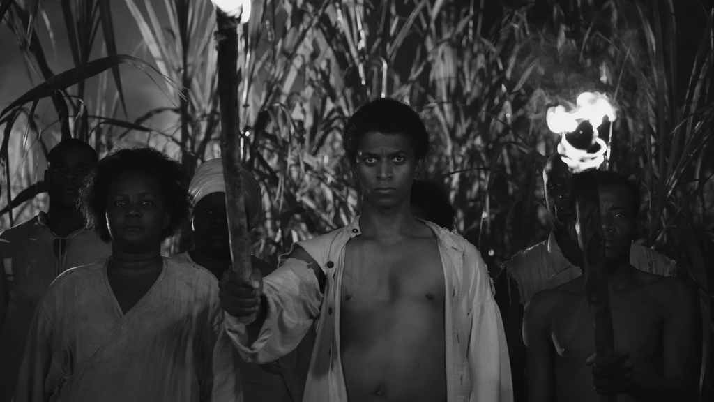group of people holding long sticks on fire